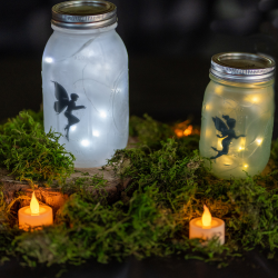  two mason jars with fairy stickers, lit up from the inside with small lights